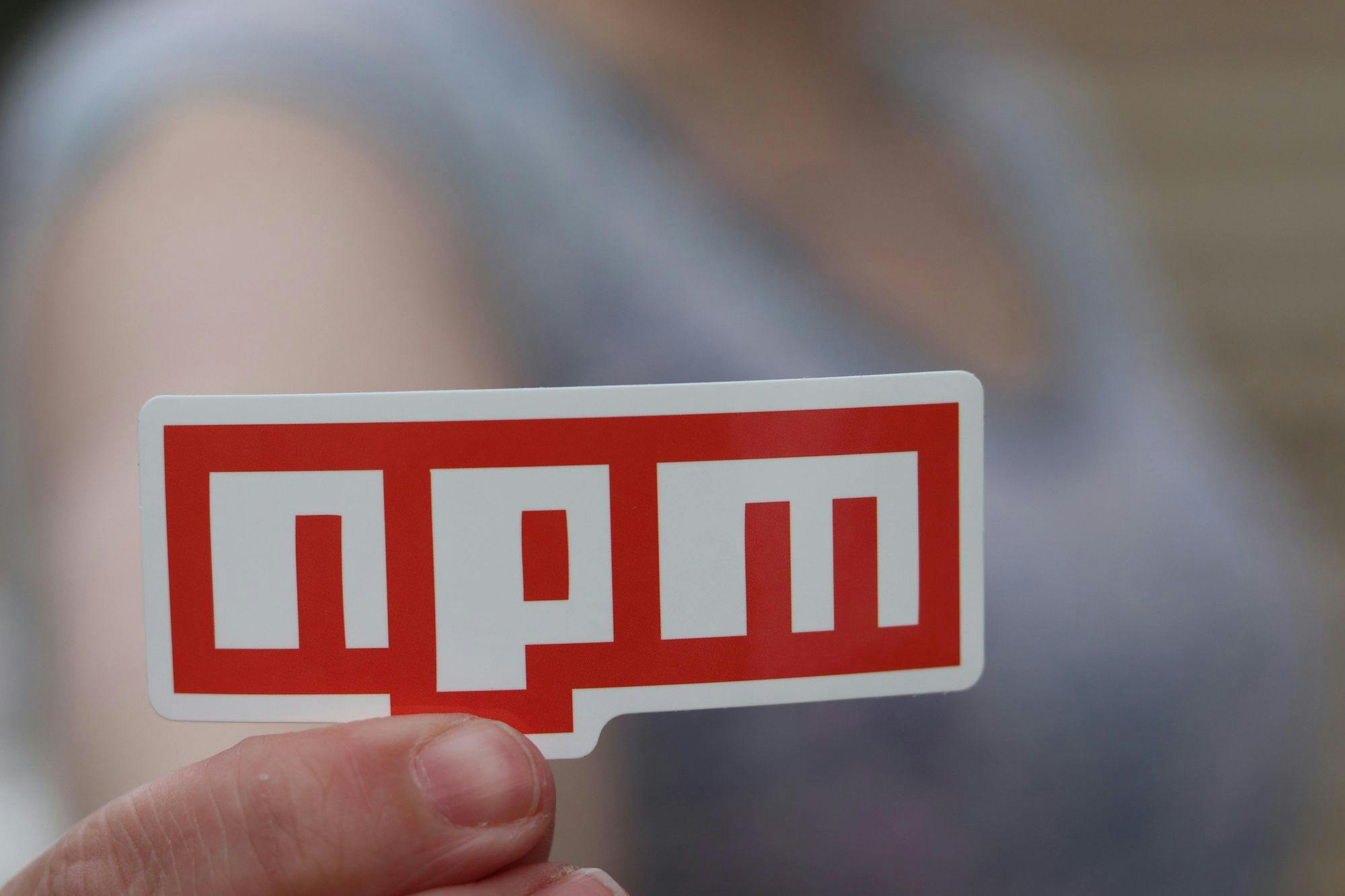 A person holding a logo of npm.